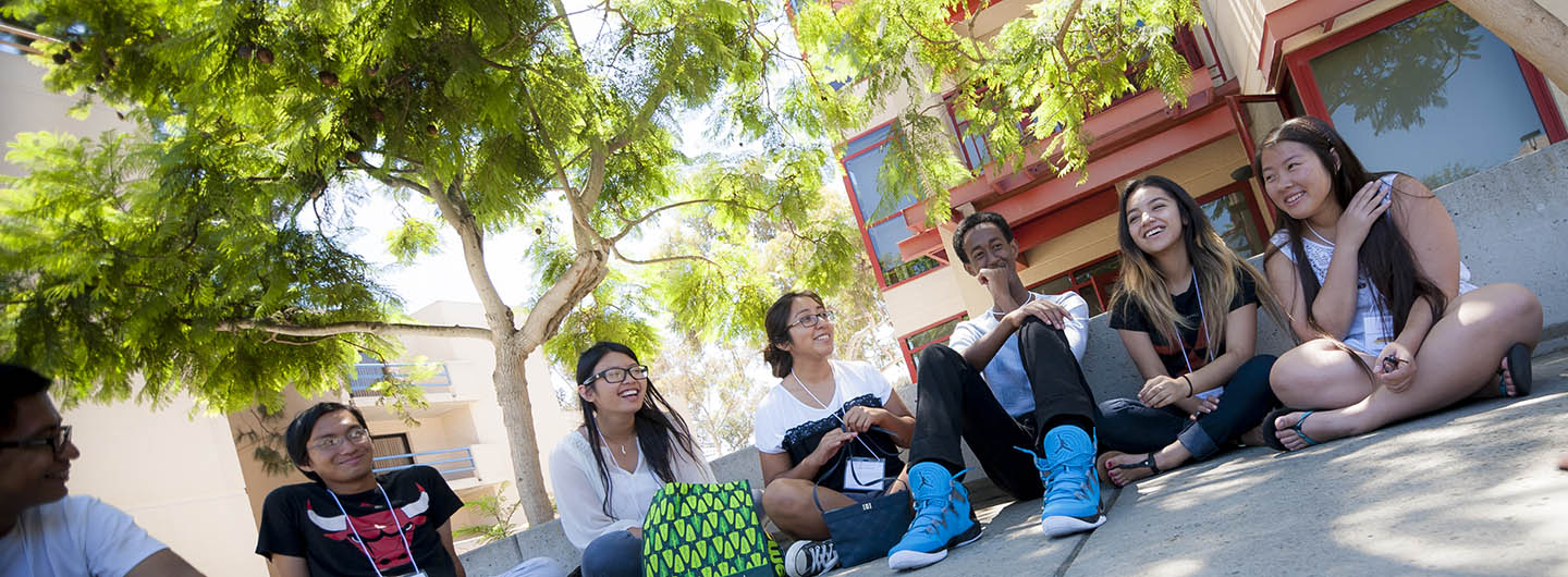 Photo of a small group of UC San Diego students sitting on campus and talking with each other - Center for Student Involvement - Communication and Leadership