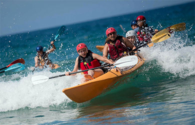 UC San Diego - Welcome Week event - Meet the Beach 2018 - students in kayak surfing a wave at La Jolla Shores beach