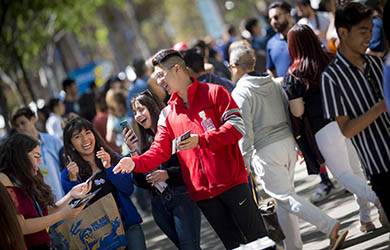 UC San Diego student passes out flyers and engages other students on Library Walk - photo by Erik Jepsen, UC San Diego Publications